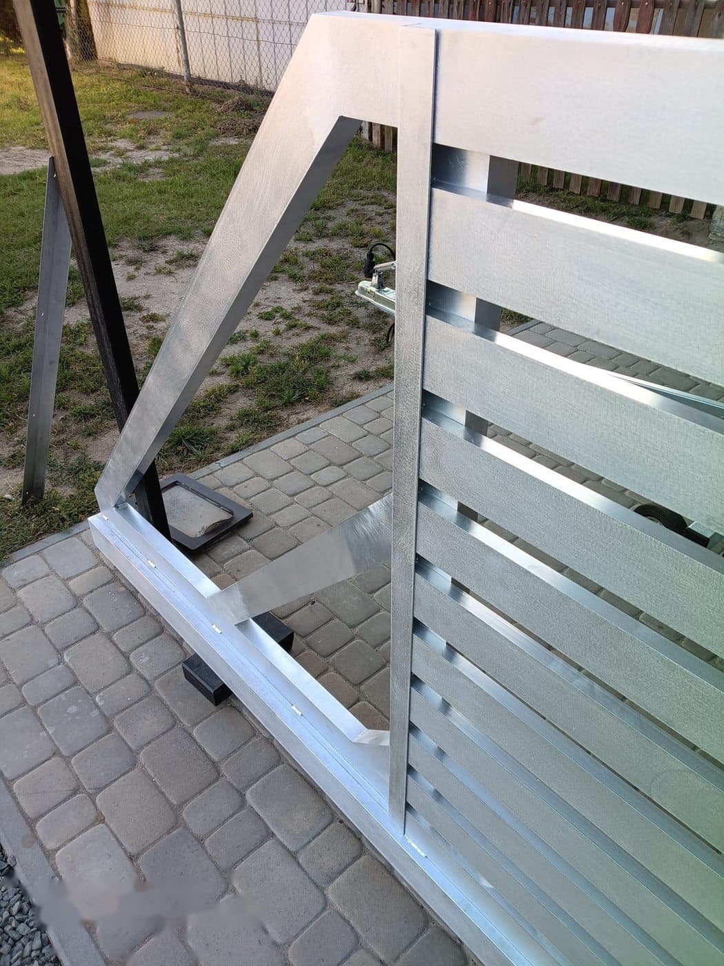 Detail mechanizmu bramy aluminiowej — zawias i uchwyt